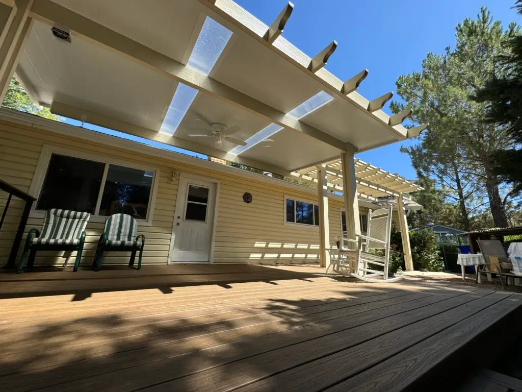 Deck area featuring a covered patio with ceiling fan, green and white striped chairs, and a wooden deck, emphasizing custom outdoor living solutions by Southwest Builders in San Diego.