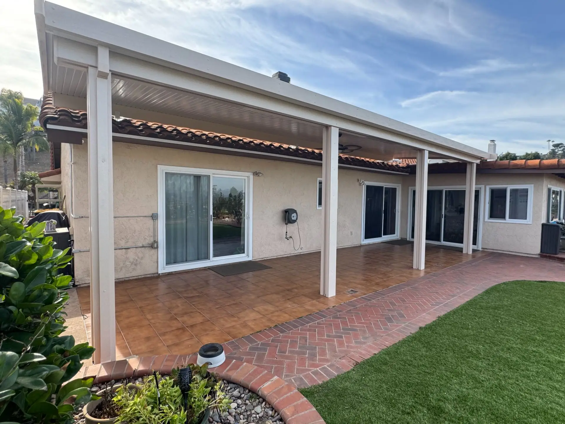 Aluminum patio cover installation enhancing outdoor living space of a single-story ranch-style bungalow in El Cajon, CA, featuring durable design and stylish integration with existing architecture.