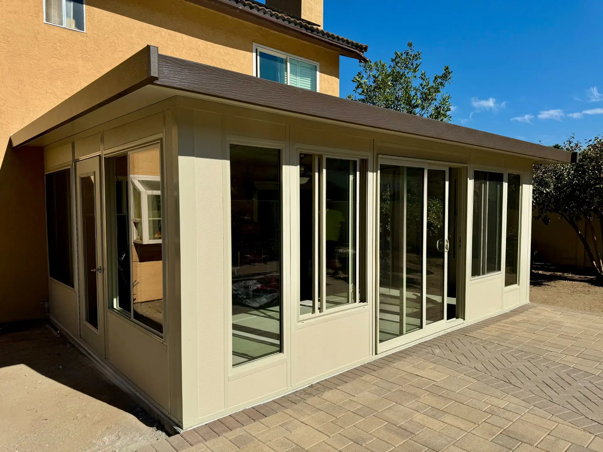 Sunroom addition in Lakeside, CA, featuring large glass windows, a raised concrete foundation, and a modern design, enhancing outdoor living space for year-round enjoyment.